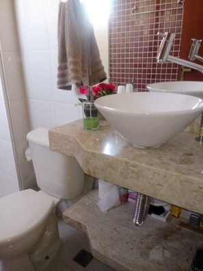 A bathroom with a white sink, a toilet, and a shower area. - Apartamentos Marina Club (Sao Pedro da Aldeia)