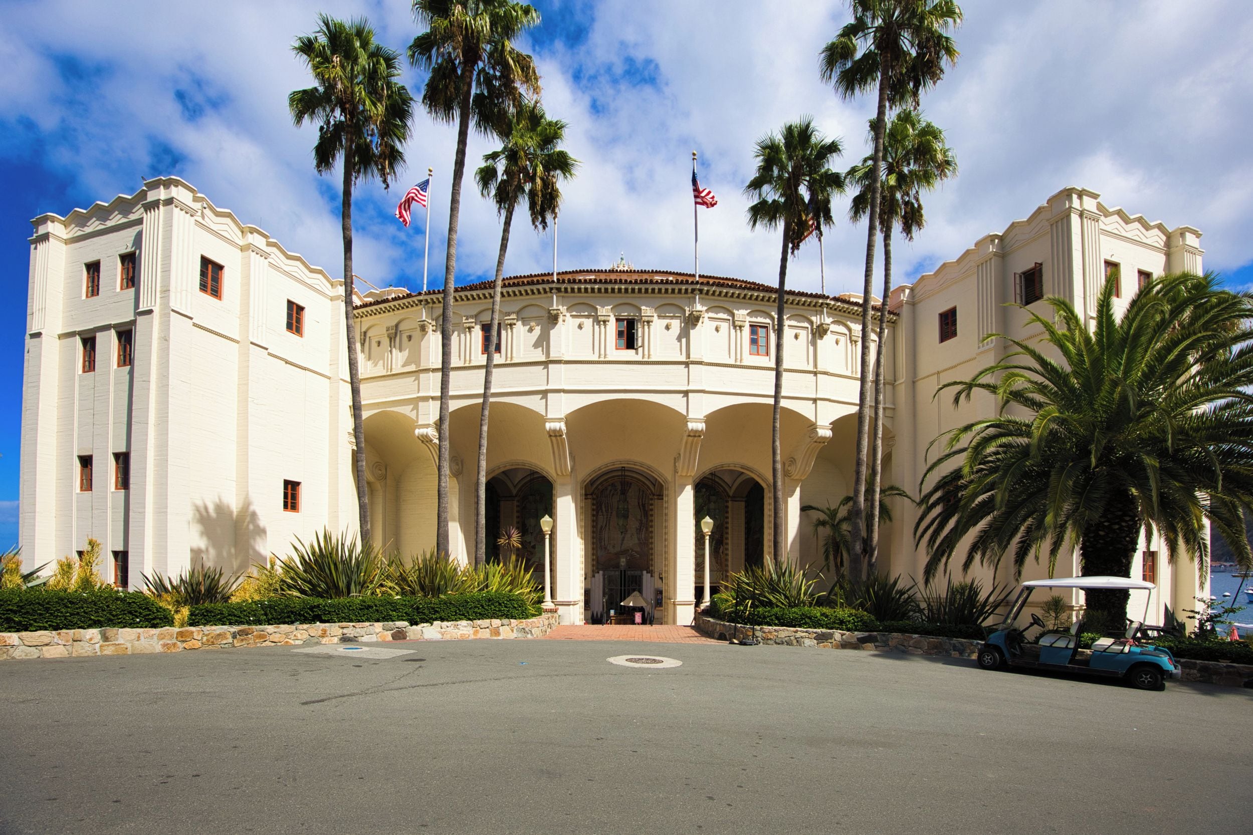 Un edificio histórico con un patio central, palmeras y banderas estadounidenses.