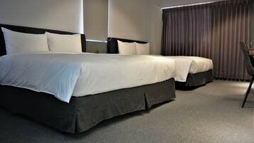 Een hotelkamer met een groot bed, een stoel en een raam met gordijnen.