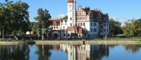 A historic building with a prominent tower and a reflection in the water.