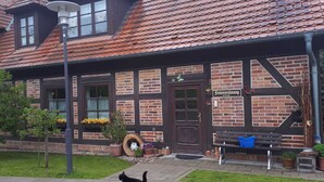 Un bâtiment traditionnel avec un toit en tuiles, une porte en bois et une enseigne sur laquelle on peut lire « Seitenwohnung ».