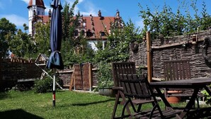 Un espace extérieur aménagé avec du mobilier en bois et une clôture en osier.