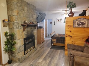 Un salón acogedor con chimenea de piedra, muebles de madera y decoración con motivos de osos.