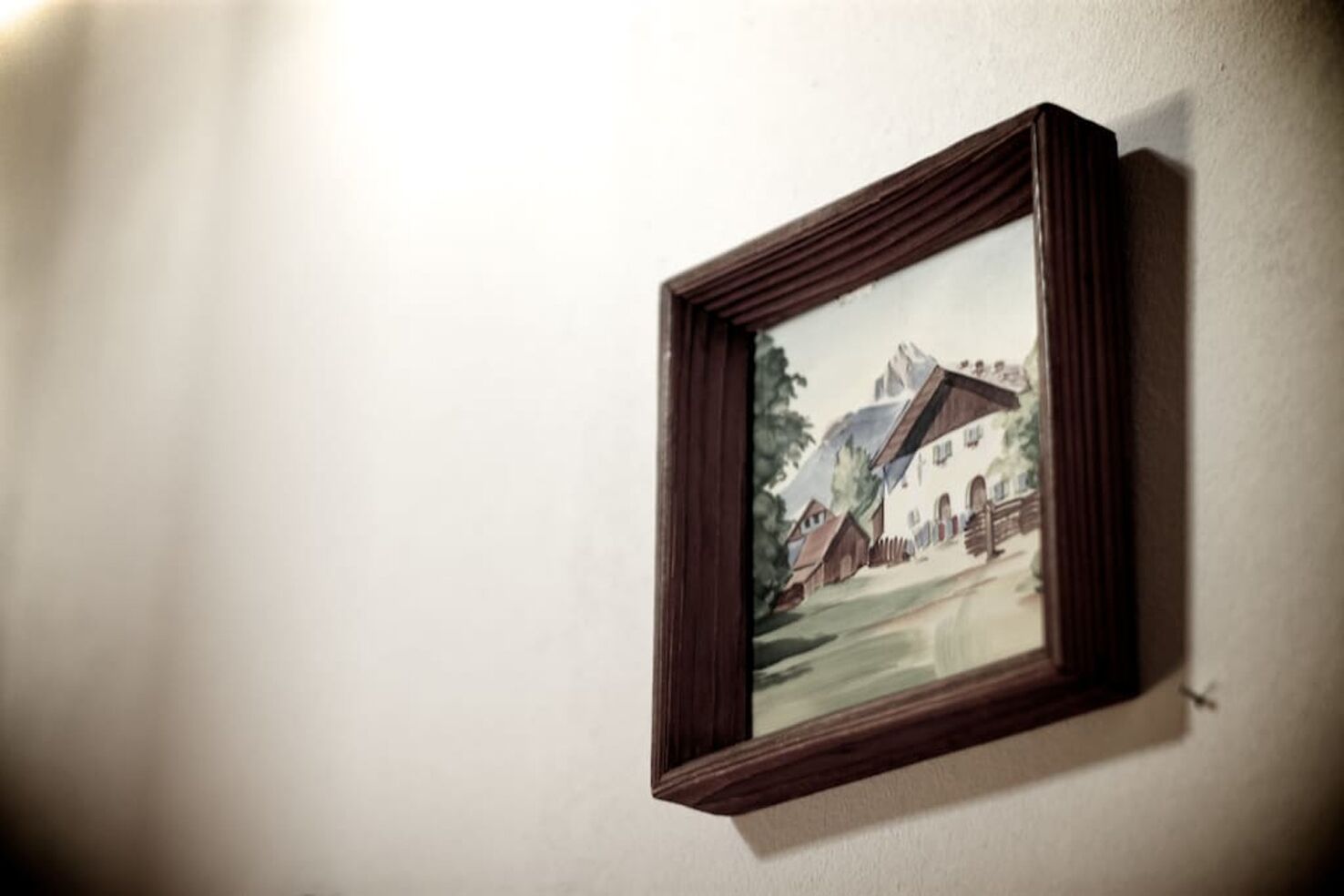 Un cuadro enmarco de un paisaje montañoso en una pared lisa.