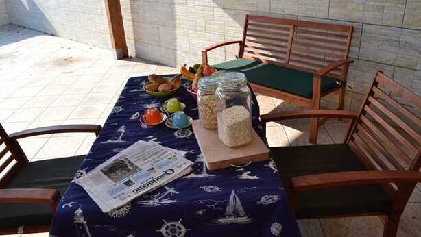 Un tavolo con un giornale, una ciotola di frutta e barattoli di snack.