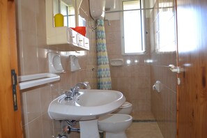 Une salle de bain équipée d’un lavabo, de toilettes et d’un rideau de douche.