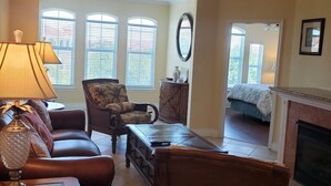 A living room with a ceiling fan, a fireplace, a sofa, a coffee table, and a chair. - ***  2 bd, 2 bath  Luxury 5 star Italian  Resort, on the hedge of the  Tampa Bay (Clearwater)
