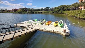 A dock with kayaks and a building in the background. - ***  2 bd, 2 bath  Luxury 5 star Italian  Resort, on the hedge of the  Tampa Bay (Clearwater)