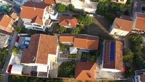 Een overzicht vanuit de lucht van een woongebied met huizen, herkenbaar aan rode dakpannen en witte muren.