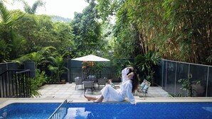 A pool area with a tiled edge, surrounded by greenery and outdoor furniture. - Casa Rio Resort Athirapilly (Chalakudy)
