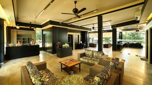 A spacious lobby with a reception desk, seating area, and a view of the outdoors. - Casa Rio Resort Athirapilly (Chalakudy)
