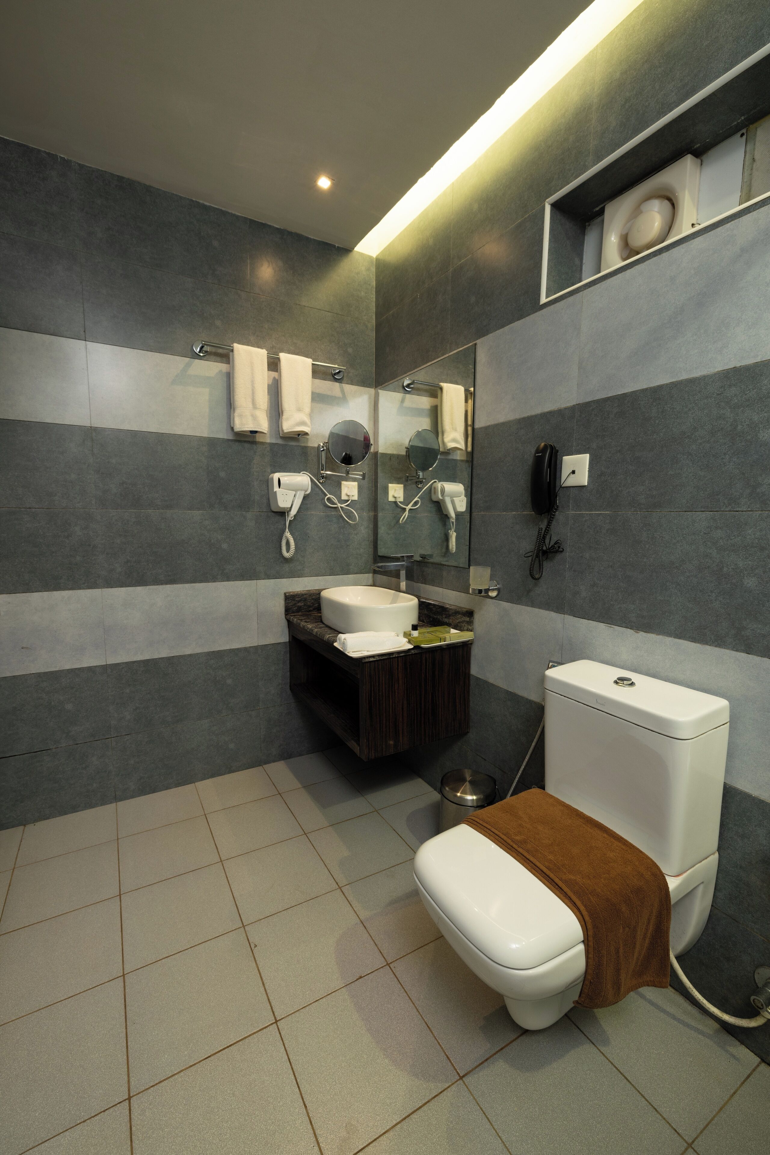 A modern bathroom with a toilet, sink, and mirror.