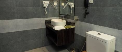 A modern bathroom with a toilet, sink, and mirror.