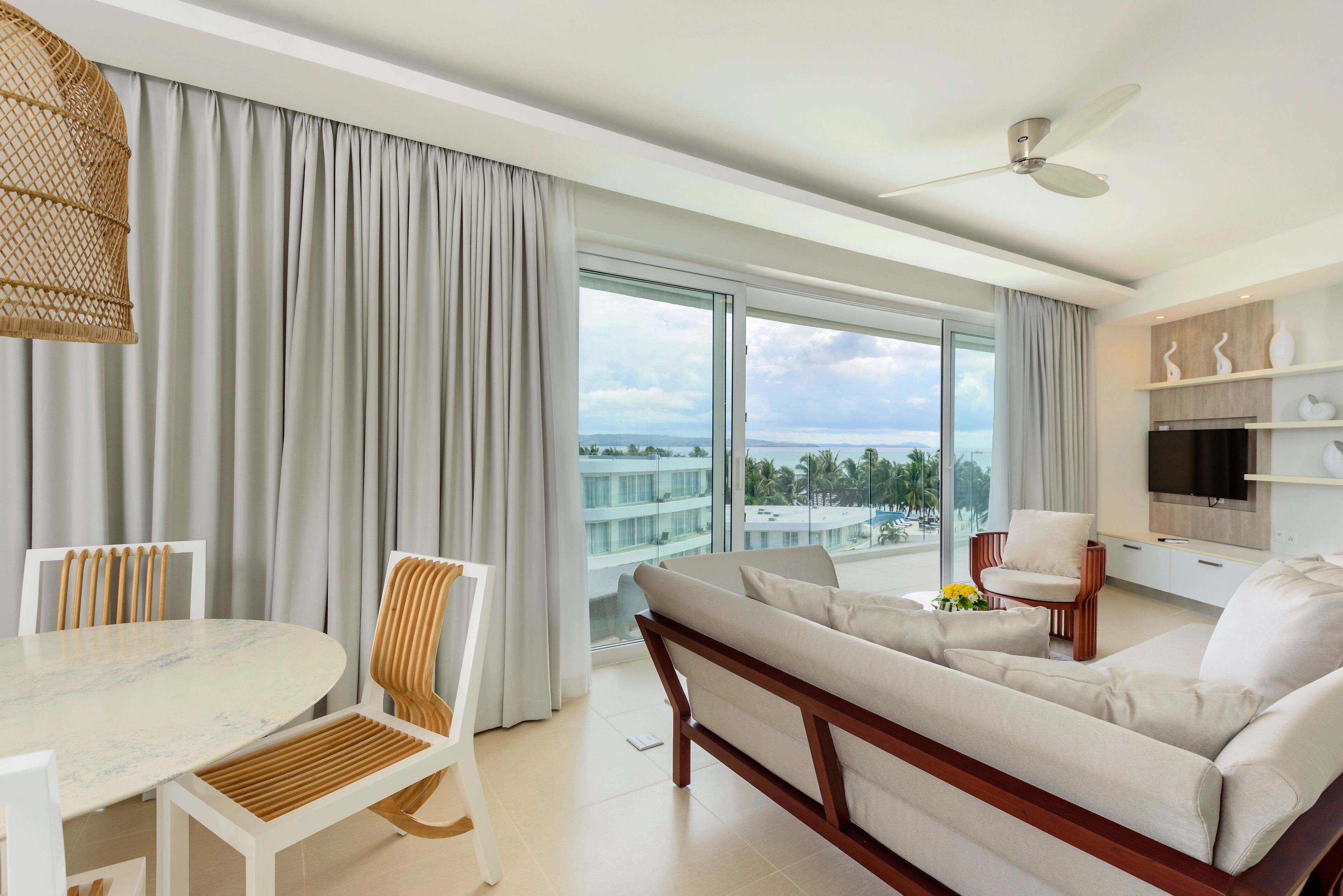 Ein modernes Hotelzimmer mit Balkon, Essbereich und Wohnbereich.