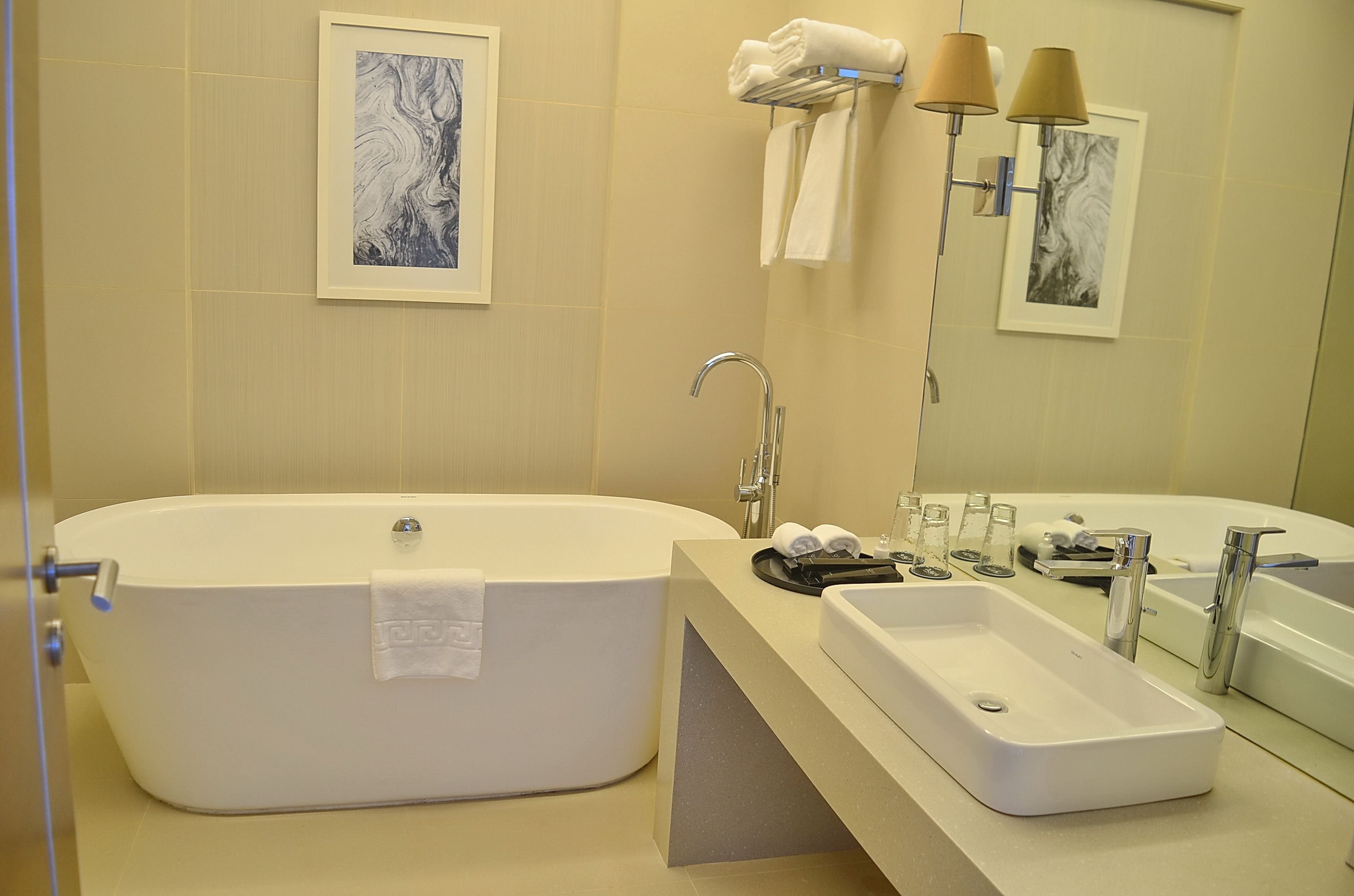 Un baño moderno con una bañera independiente, un lavabo y un mueble de tocador.
