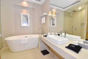 Un bagno moderno con una vasca freestanding, un lavabo doppio e uno specchio grande.