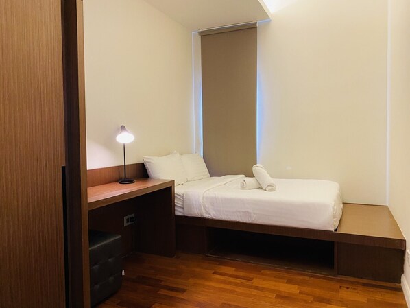 Una habitación pequeña y funcional con cama, escritorio y silla.