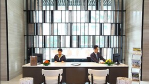 A reception area with a modern design, featuring a reception desk, two chairs, and a small plant. - Tribeca Serviced Hotel by Millennium (Kuala Lumpur)