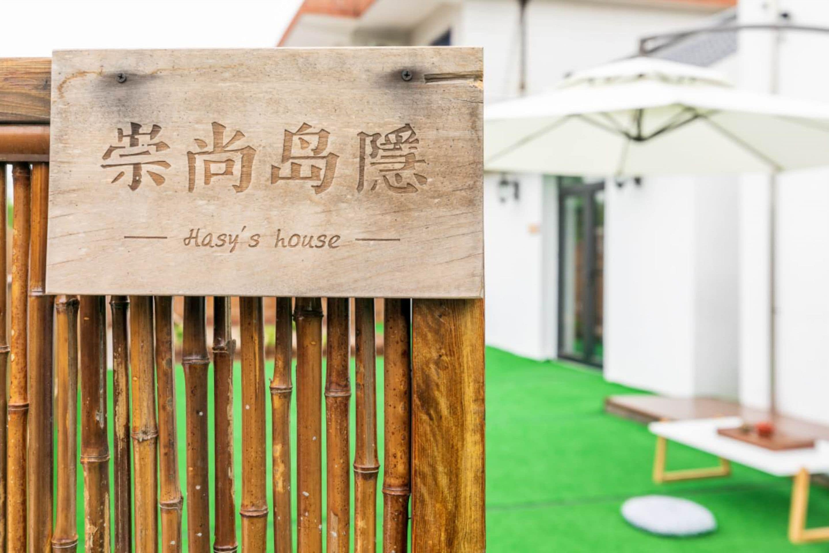 Uma placa de madeira com caracteres chineses e o texto 'Hasy's house' em inglês.