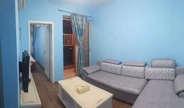 Habitación doble Deluxe | Área de sala de estar | Televisión de pantalla plana