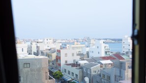 A cityscape with buildings and a body of water in the background. - Bowa Hotel (Magong)