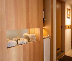 Un mostrador de recepción de madera con un refrigerador blanco y un cuadro en la pared.