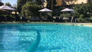 A clear swimming pool with lounge chairs and umbrellas around it. - Villa Royal (Florence)