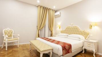 A bedroom with a large bed, a chair, a bench, and a nightstand.
