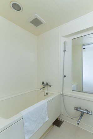 A white bathroom with a bathtub, a shower, a mirror, and a vent on the ceiling.
