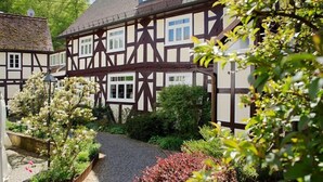 Un bâtiment traditionnel à colombages, avec un chemin pavé menant à l’entrée.