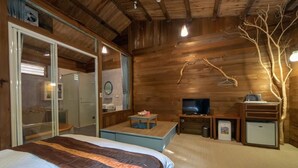 A wooden cabin room with a bed, a TV, a small table, and a mirror. - Shankou Hotspring Hotel (Jiaoxi)