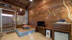 A cozy room with a wooden ceiling, a television, a small refrigerator, and a bench. - Shankou Hotspring Hotel (Jiaoxi)