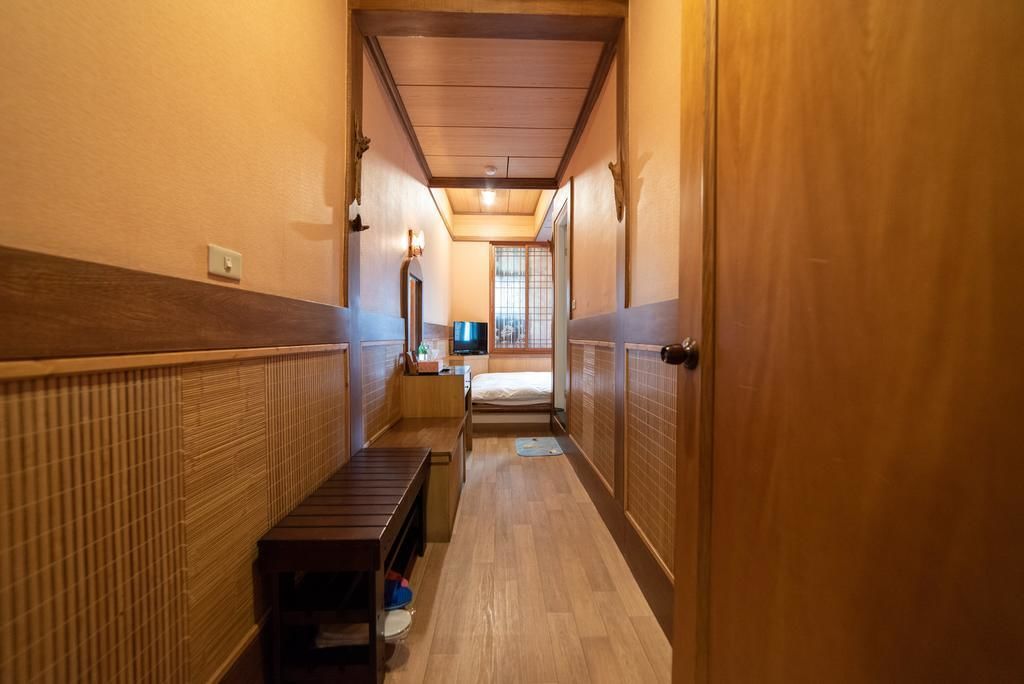 A narrow hallway with wooden walls and a bench.