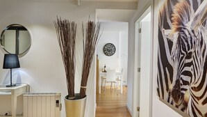 Ein modernes Interieur mit einem Flur, der in einen Essbereich führt, inklusive Heizkörper, Lampe und einem großen Zebra-Gemälde.