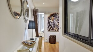 Ein Flur mit Spiegel, Lampe, einem Zebra-Kunstwerk und einem Koffer.
