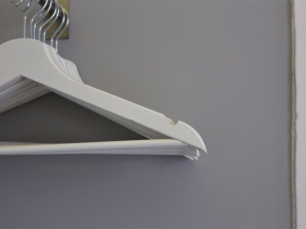 A white hanger with a folded garment against a grey wall. - Sonel Investe Apartments Praça da Figueira (Lisbon)