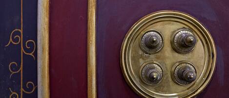 A close-up of a vintage radio with a circular dial and three knobs.