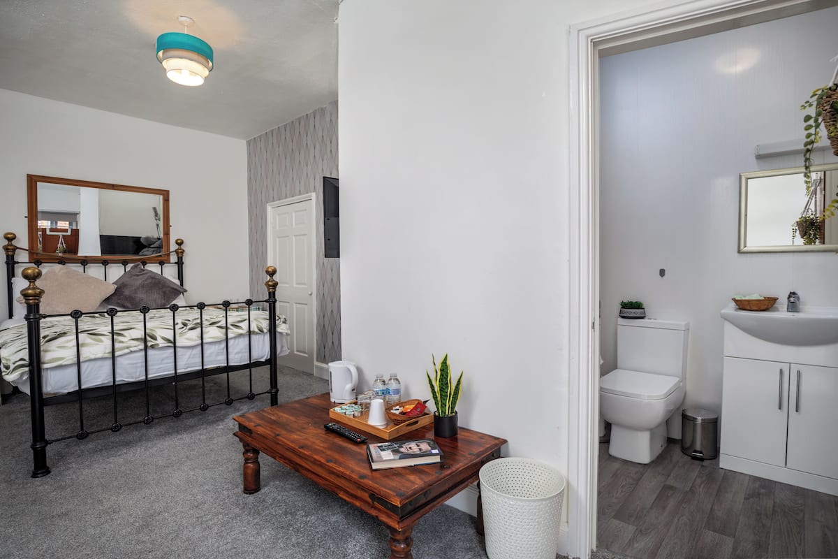 Une chambre à coucher avec un lit, une table de chevet et un miroir.