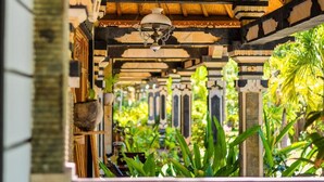 A traditional wooden structure with a tiled roof, a hanging lamp, and potted plants.