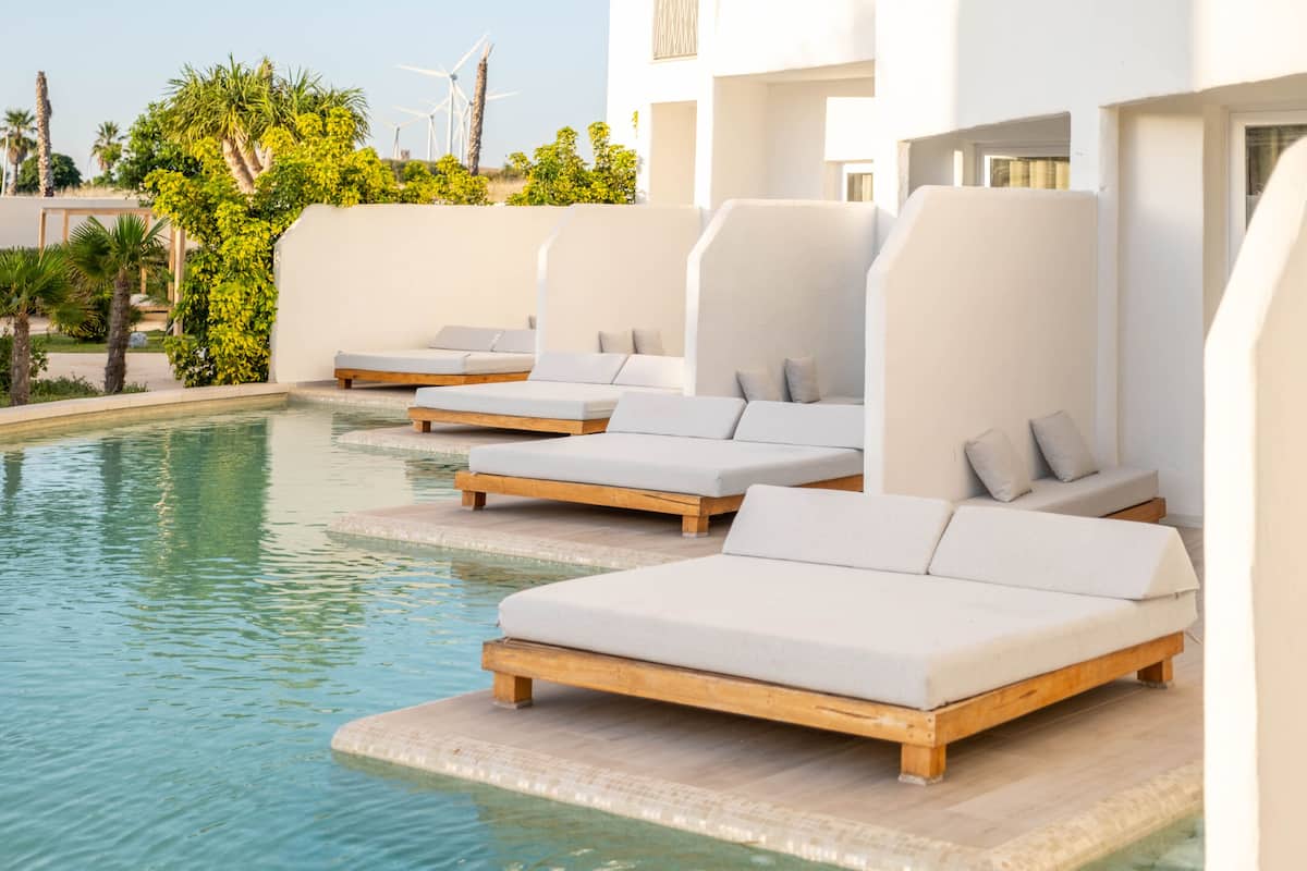 A poolside area with lounge chairs and a pool.
