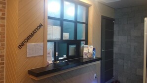 Un mostrador de recepción con un panel de pared de madera con la etiqueta