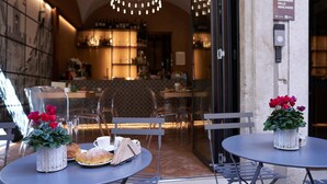 An outdoor café with tables, chairs, and potted plants. - Locanda delle Mercanzie (Brescia)