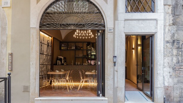 A restaurant with a glass facade, interior lighting, and a chandelier. - Locanda delle Mercanzie (Brescia)