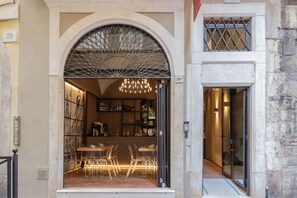 A restaurant with a glass facade, interior lighting, and a chandelier. - Locanda delle Mercanzie (Brescia)