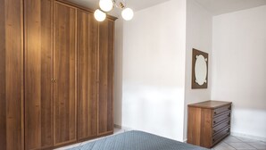 A bedroom with a large wardrobe, a bedside table, and a mirror on the wall. - N203 - Numana, large three-room apartment with porch (Numana)