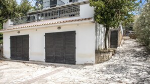 A building with a white facade, two dark shutters, a balcony with metal railings, and a cobblestone pathway. - N203 - Numana, large three-room apartment with porch (Numana)