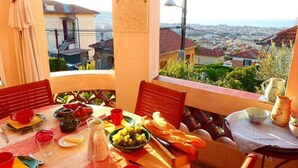 A table set for a meal with a view of a cityscape. - Villa Bennecourt (Nice)