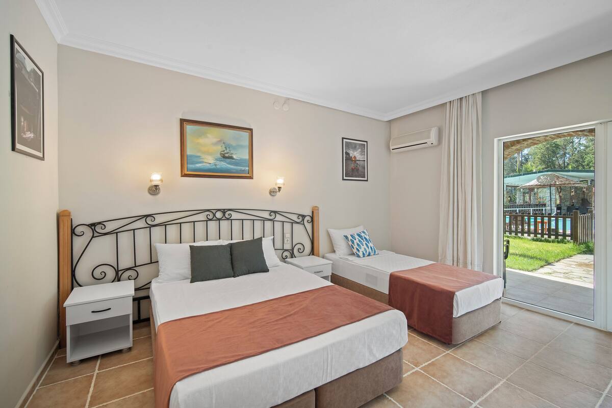Une chambre d’hôtel avec deux lits, une grande fenêtre et une vue sur l’extérieur.