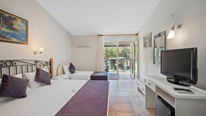 A hotel room with two beds, a TV, a desk, and a balcony with a view. - Alados Otel (Marmaris)