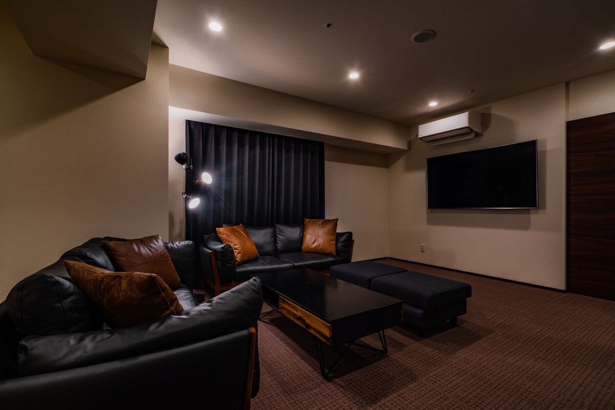 Ein modernes Wohnzimmer mit einem Ecksofa, einem Couchtisch und einem an der Wand montierten Flachbildfernseher.